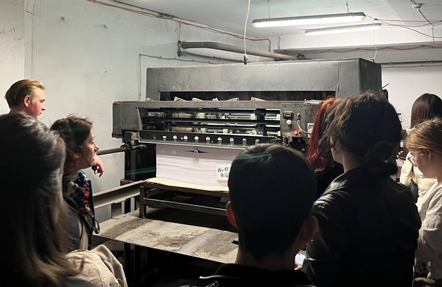 Студенти спостерігають за роботою паперорізального верстату